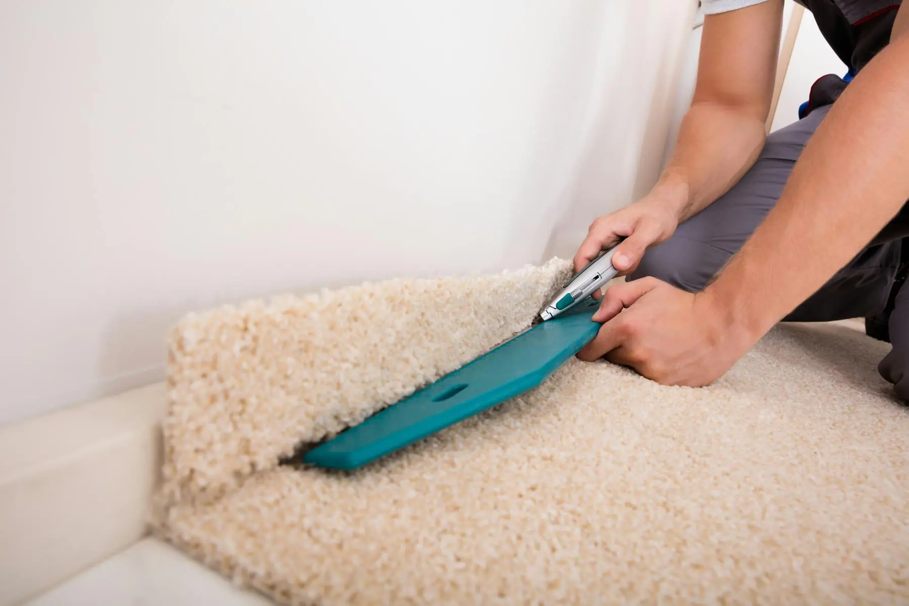 Carpet being trimmed and tucked along a step edge during installation