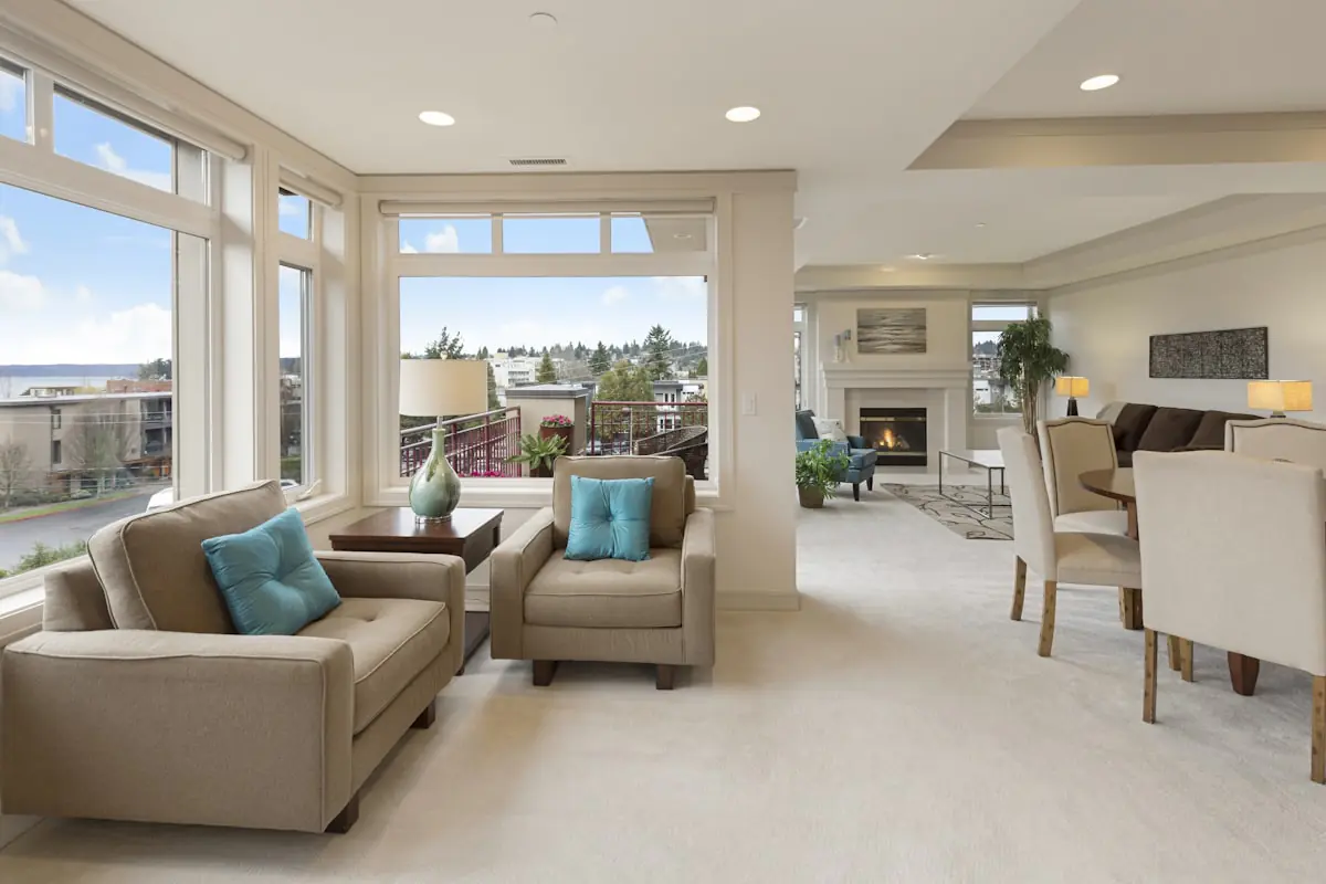 Open living and dining area with light wall to wall carpet
