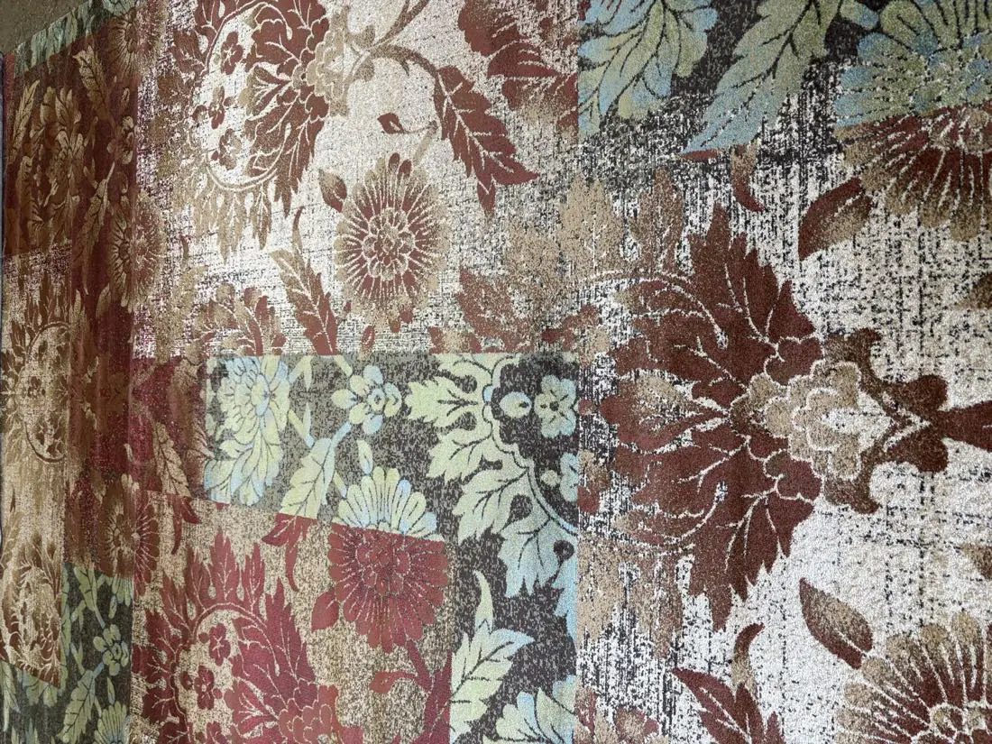 Patchwork floral area rug in warm reds and golds